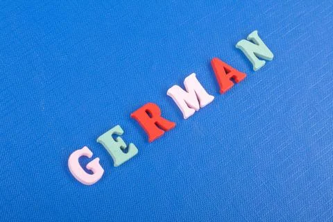 German word on blue background composed from colorful abc alphabet block wo.. Stock Photos