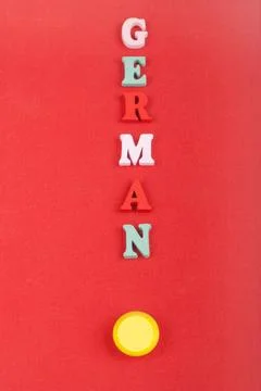 German word on red background composed from colorful abc alphabet block woo.. Stock Photos