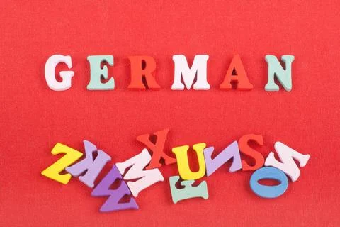 German word on red background composed from colorful abc alphabet block woo.. Stock Photos