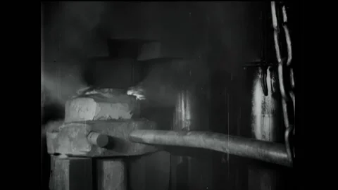 GERMANY - 1918 - Fire bursts from the block’s top as a worker pokes it with a Stock Footage 322761274
