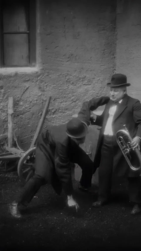 GERMANY - 1924 - in this silent comedy, a drunk plays the tuba in a courtyard Stock Footage 339809387