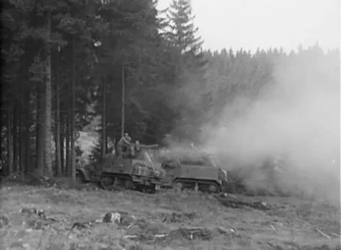 GERMANY - 1944: Hazy position - Smoke surrounds half-tracks at forest edge Stock Footage 344486705