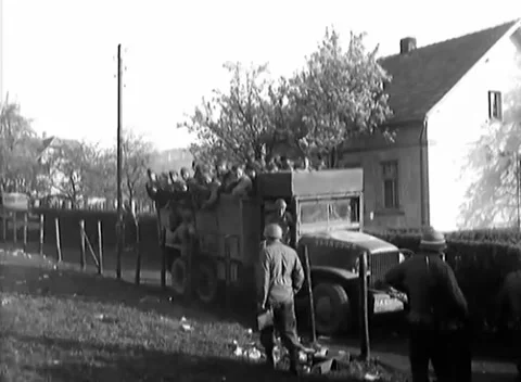 GERMANY - 1945: Captive transport - Prisoner trucks load beside mass assembly Stock Footage 344493647
