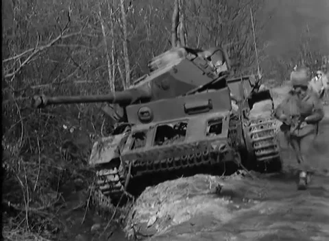 GERMANY - 1945: Disabled armor - Troops File Past a Thrown-Track Wreck Stock-Footage 344494045