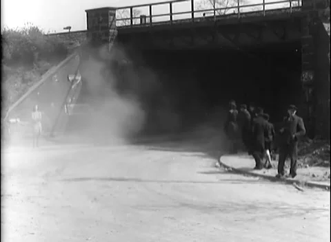 GERMANY - 1945: Dusty underpass - Tracked vehicle passes gathered onlookers Stock Footage 344488488