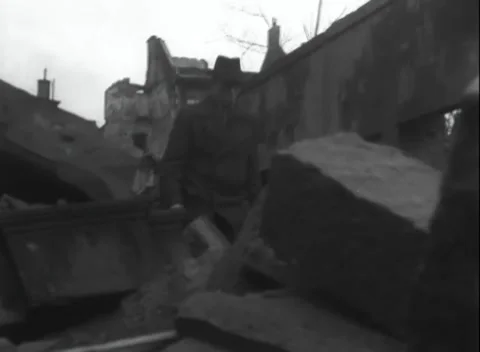 GERMANY - 1945: Fedora-clad climber - Civilians cross a bombed city square Stock Footage 344600082