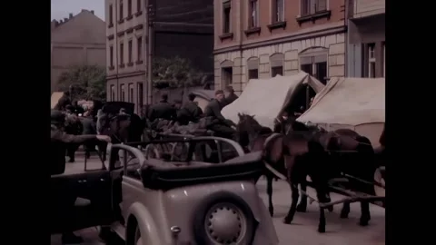 GERMANY - 1945 - German evacuees drive wagons through a city street past Video stock 313207564