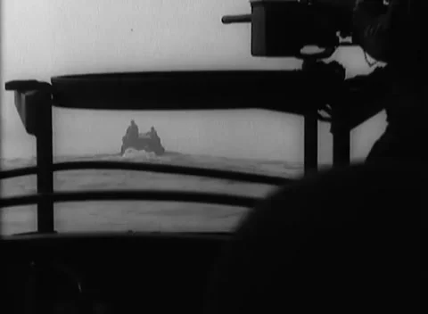GERMANY - 1945: Gun muzzle framing - Small craft cross past deck rails Видео 344600374