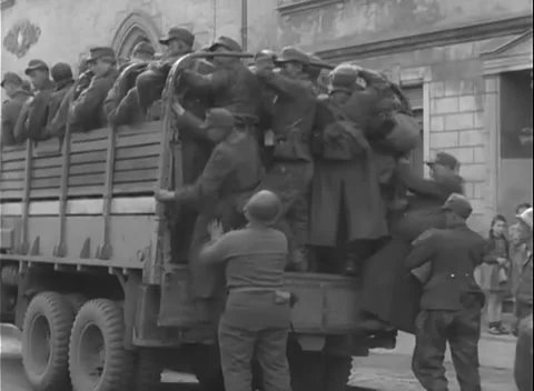 GERMANY - 1945: Hands gripping stake sides - Men stand packed in a truck bed Stock Footage 344598842