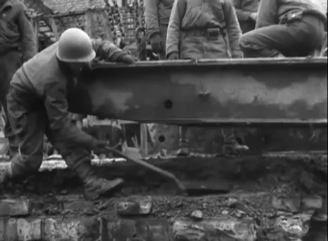 GERMANY - 1945: A mortared abutment - Soldier guides a steel box girder Stock Footage 344600070