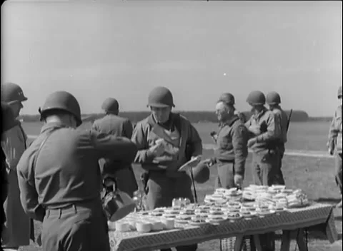 GERMANY - 1945: Open-field catering - Troops eat beside a long trestle table 動画素材 344488382