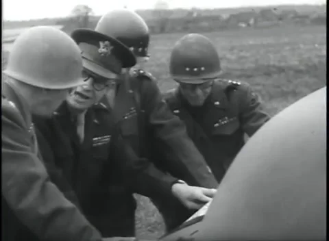 GERMANY - 1945: Paper spread on bonnet - Officers study a map on a car Stock Footage 344598425