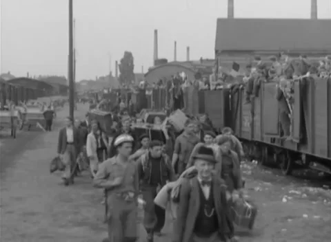 GERMANY - 1945: Repatriation transit - People carry bundles along boxcar line Stock Footage 344487375