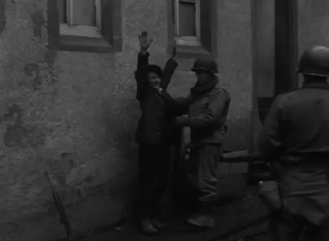 GERMANY - 1945: Security search - US Soldier Searches a Detainee Against a Wall Stock Footage 344492615