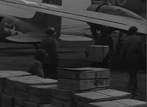 GERMANY - 1945: Strapped cargo - Servicemen unload cartons from aircraft Stock Footage 344487552