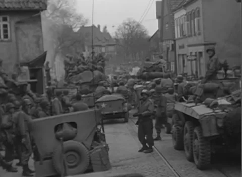 GERMANY - 1945: Street-side briefing - Armored column staff study a route map Stock Footage 344487577
