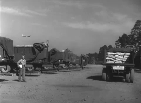 GERMANY - 1948: Apron queue - Supply convoy waits with towering sack loads Video stock 344496308