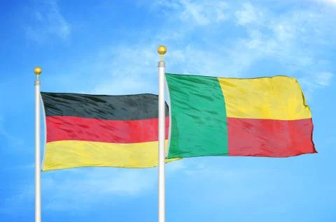 Germany and Benin two flags on flagpoles and blue cloudy sky Stockfoto's