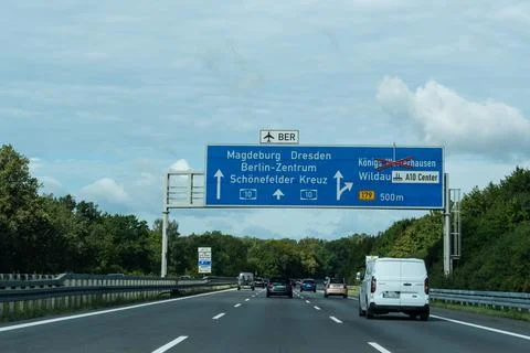 Germany - Aug 22, 2026: White van and cars driving towards a blue gantry board Stock Photos