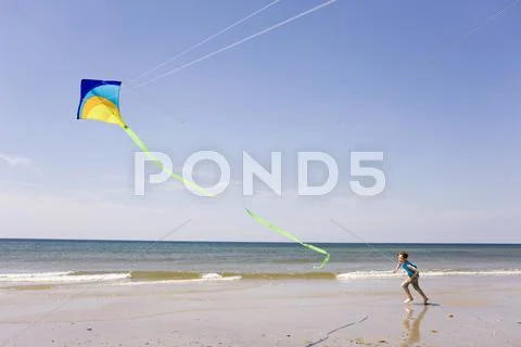 Germany, Baltic Sea, Boy (8-9) Flying Kite At Beach