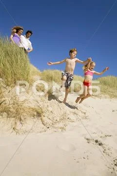 Germany, Baltic sea, Family in sand dunes, children jumping down sand dunes Stock-Fotos