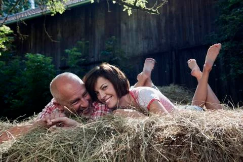 Germany, Bavaria, Couple lying on haystack Stock Photos