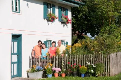 Germany, Bavaria, Four persons standing at garden fence, portrait Stock Photos