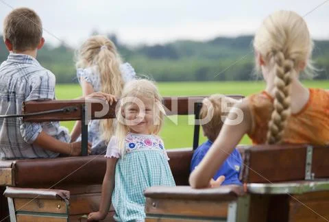 Germany, Bavaria, Group of children sitting on cart Stock Photos
