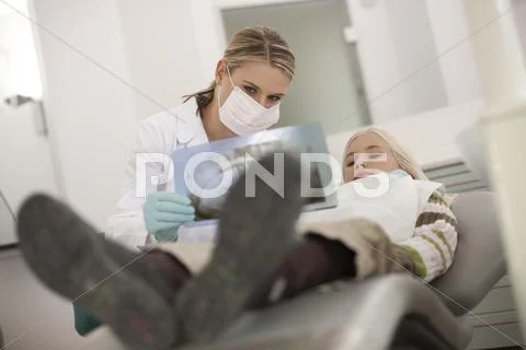 Germany, Bavaria, Landsberg, Female Dentist Assistant Showing Girl (8-9) An X