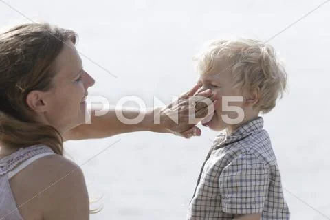 Germany, Bavaria, Mother washing dirt from her sons face Stock-Fotos