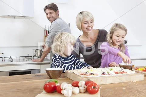 Germany, Bavaria, Munich, Family preparing pizza in kitchen Stock Photos