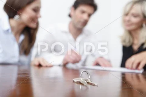 Germany, Bavaria, Munich, Keys on table with real estate agents in background Stock-Fotos