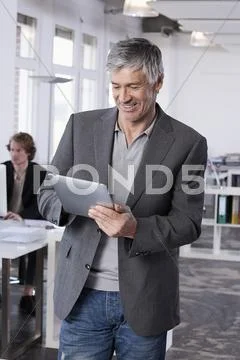 Germany, Bavaria, Munich, Mature man using digital tablet, colleague working in Stock Photos