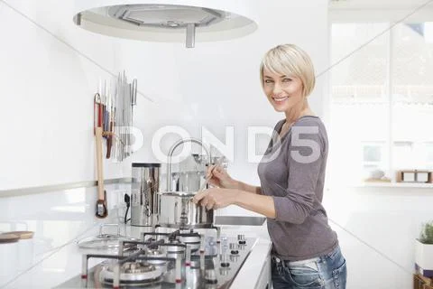 Germany, Bavaria, Munich, Woman preparing food in kitchen Stock Photos