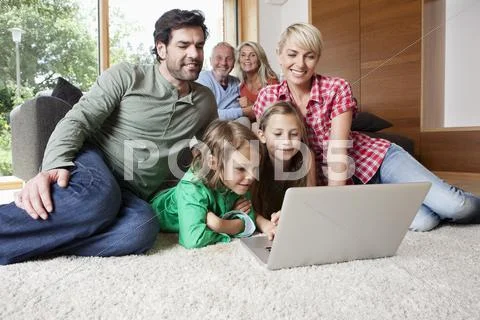 Germany, Bavaria, Nuremberg, Family using laptop in living room Stock-Fotos