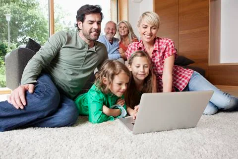 Germany, Bavaria, Nuremberg, Family using laptop in living room Stock Photos