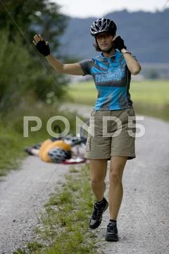 Germany, Bavaria, Oberland, Woman gesturing, fallen biker in background Stock Photos