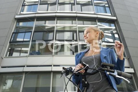 Germany, Bavaria, Teenage girl with cell phone and listening music, smiling Stock-Fotos