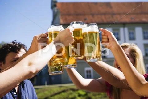 Germany, Bavaria, Upper Bavaria, Cheerful people toasting each other in beer Stock Photos