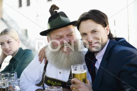 Germany, Bavaria, Upper Bavaria, Man in traditional cosume and businessman in Stock Photos