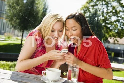 Germany, Bavaria, Upper Bavaria, Two young women in beer garden looking amused Stock Photos