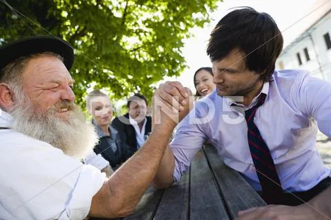 Germany, Bavaria, Upper Bavaria, Two men in beergarden arm wrestling Stock Photos