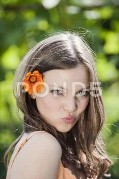 Germany, Bavaria, Woman with flower in hair, pouting lips, portrait, close-up Stock Photos