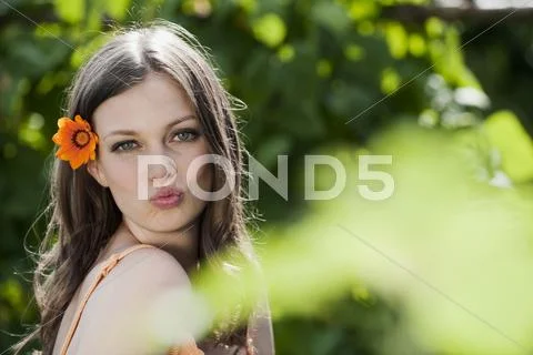 Germany, Bavaria, Woman with flower in hair, pouting lips, portrait Stock Photos