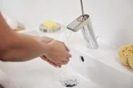 Germany, Bavaria, Young Woman Washing Hands In Bathroom Sink Stock Photos
