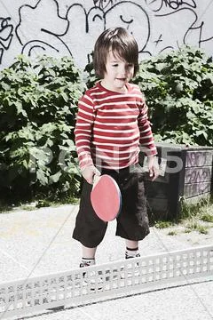Germany, Berlin, Boy (3-4) holding table tennis racket Stock Photos