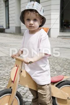 Germany, Berlin, Boy (3-4) with bicycle, portrait, close-up Stock Photos