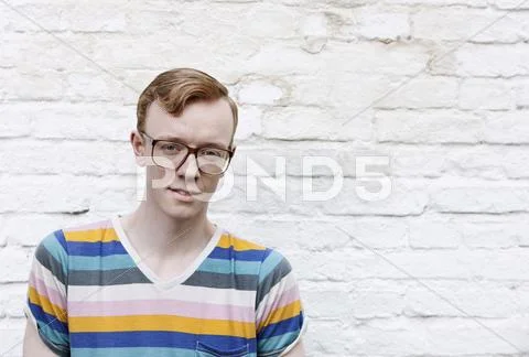 Germany, Berlin, Close up of young man with glasses, smiling, portrait Stock Photos