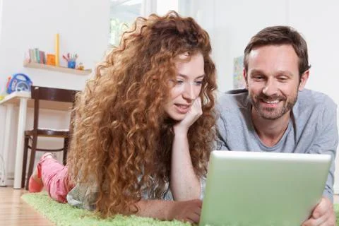 Germany, Berlin, Couple using digital tablet on floor Stock Photos