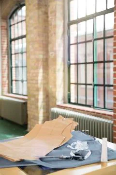 Germany, Berlin, Cut pattern and fabric on table at men's tailor Stock Photos